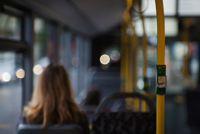 Rear view of woman sitting in bus