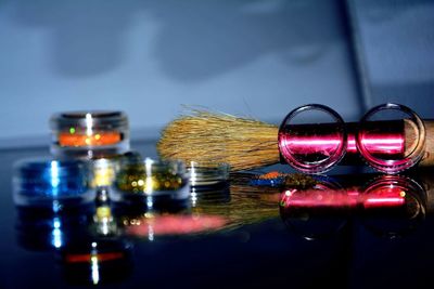 Close-up of colorful containers by shaving brush on table