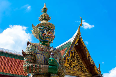 Low angle view of demon statue at grand palace against sky