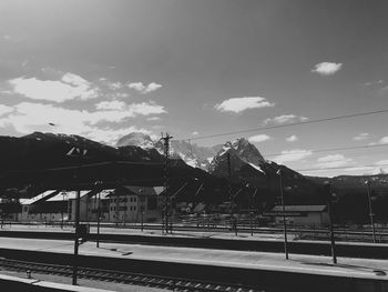 Road by railroad tracks against sky