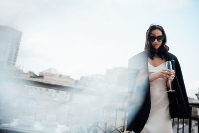 Portrait of woman standing against sky