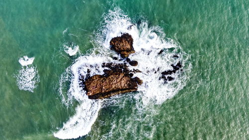 High angle view of wave splashing on rock