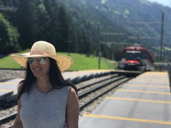Portrait of beautiful woman walking against train