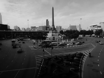 Vehicles on road in city against sky