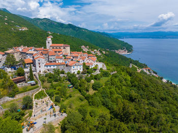 High angle view of townscape by sea against sky