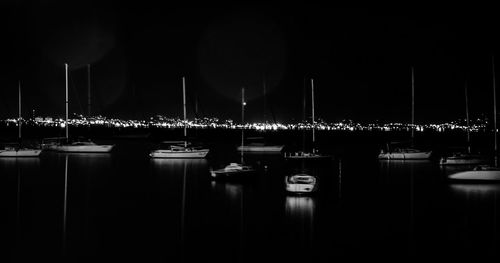 Row of illuminated lights in water at night