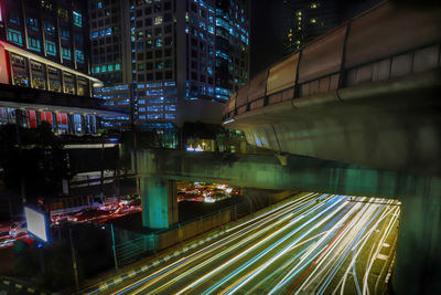 High angle view of light trails on street amidst buildings at night