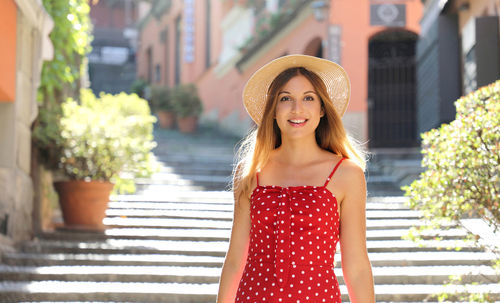 Portrait of smiling young woman standing in city