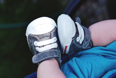 Low section of baby wearing shoes