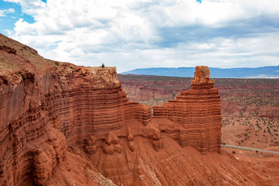 Scenic view of rock formations against cloudy sky