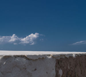 White painted retaining wall against sky during sunny day