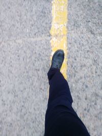 Low section of person standing on road