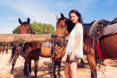 Portrait of young woman riding horse in desert