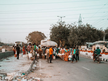 Group of people walking on road in city