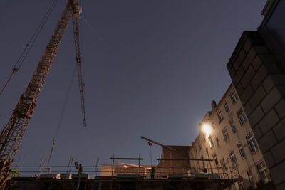 Low angle view of crane against clear sky