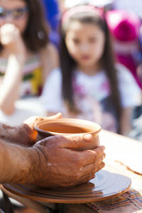 Midsection of potter making bowl in market