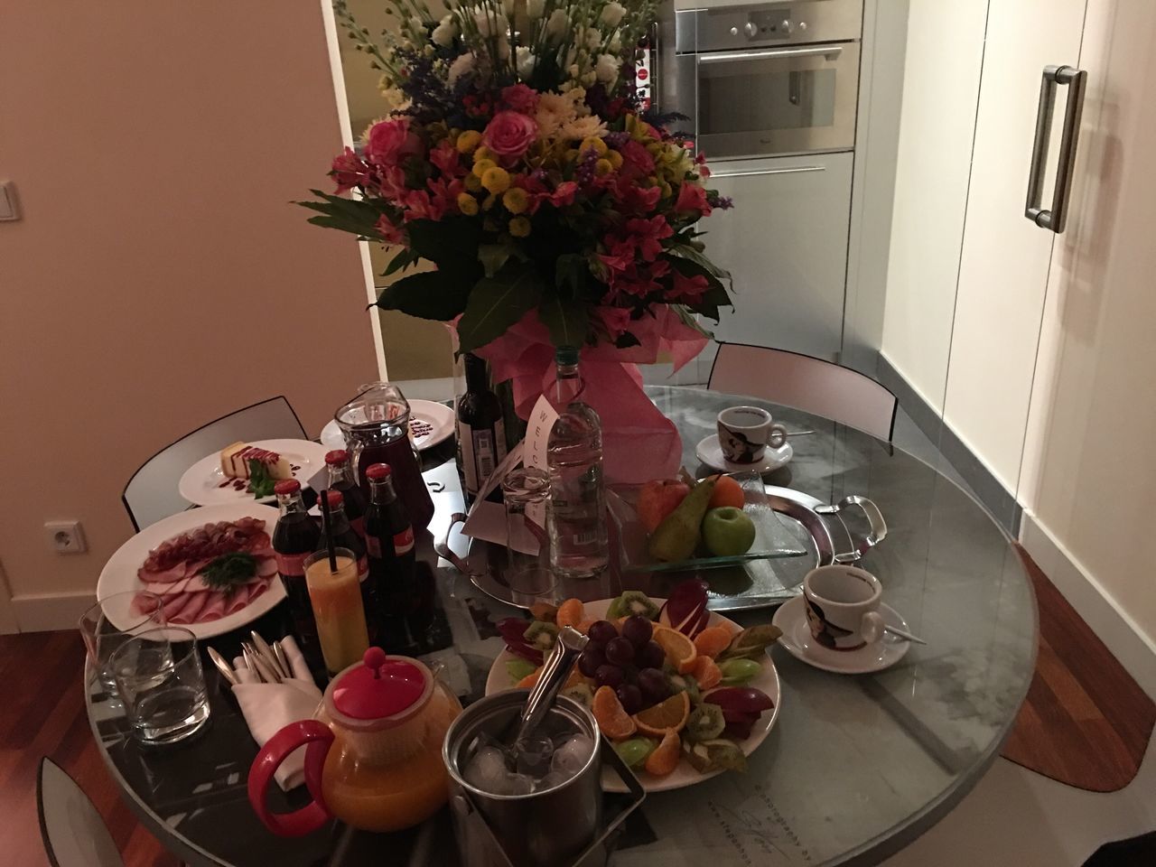 flower, table, vase, plate, food and drink, place setting, drink, indoors, food, dining table, no people, refreshment, drinking glass, fruit, serving size, freshness, breakfast, healthy eating, bouquet, wineglass, day