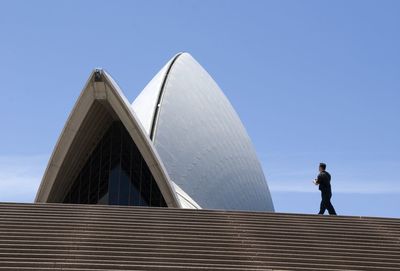 Low angle view of modern office building against blue sky