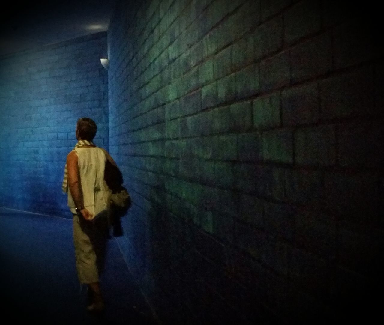 wall - building feature, standing, lifestyles, men, rear view, brick wall, person, full length, casual clothing, relaxation, blue, solitude, subway station