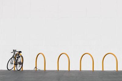 Bicycle parker in rack against white wall