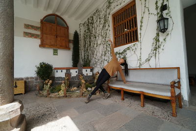 Man relaxing on bench by building