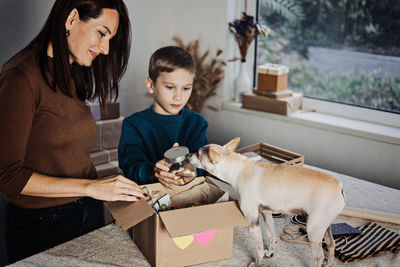 Support local business, small business. pet shop owner, mom and kid putting bone in pet