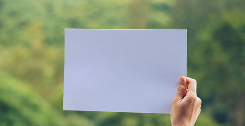 Midsection of woman holding paper with text