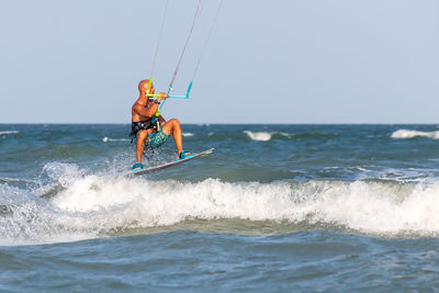 Man surfing in sea against sky