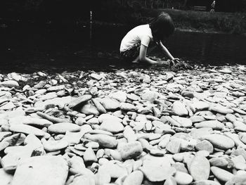 Full length of girl with pebbles on rock