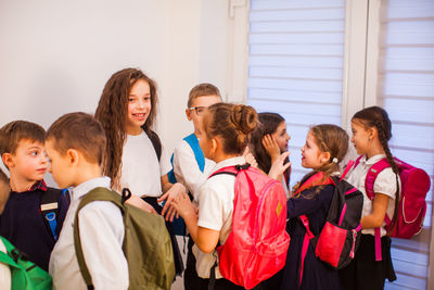 Students standing against wall at school