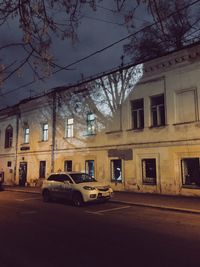 Cars on street by buildings in city at night