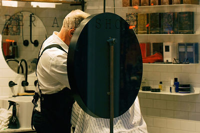 Rear view of man standing at home