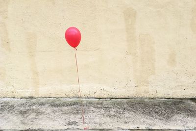 Pink balloon tied on footpath