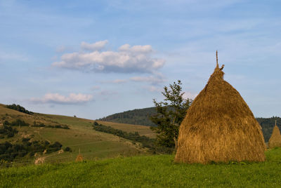 Hay bales on field against sky