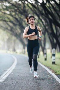 Portrait of young woman standing on road