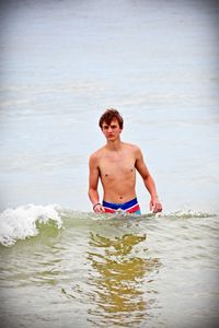 Portrait of shirtless man in sea