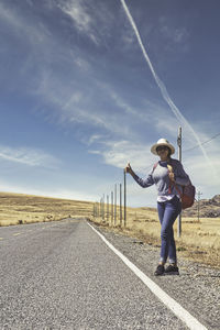 Full length of man standing on road against sky