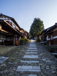 Footpath amidst buildings against sky