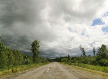 Road amidst trees against sky