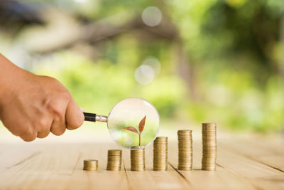 Close-up of hand holding coins on table