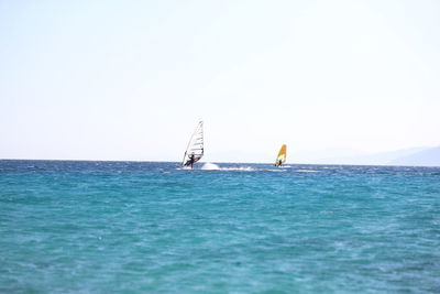 Sailboat sailing on sea against clear sky