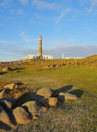 Lighthouse amidst buildings against sky