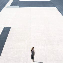 Woman with umbrella standing on tiled floor