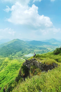 Panoramic hilltop view of lust green hills on a background of blue sky