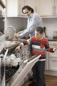 Boy helping father in kitchen