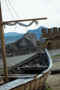 Abandoned boat moored on shore against sky
