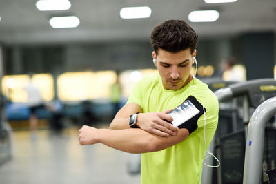 Woman listening music while standing in gym