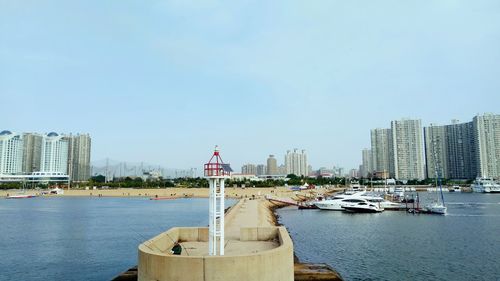 City by river against clear sky