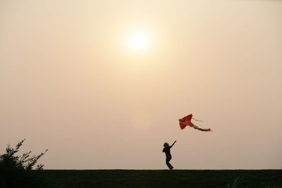 Silhouette person against sky during sunset