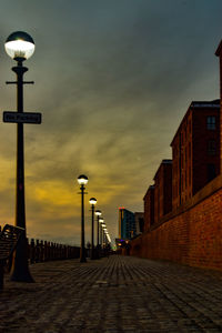 Street light on footpath amidst buildings in city